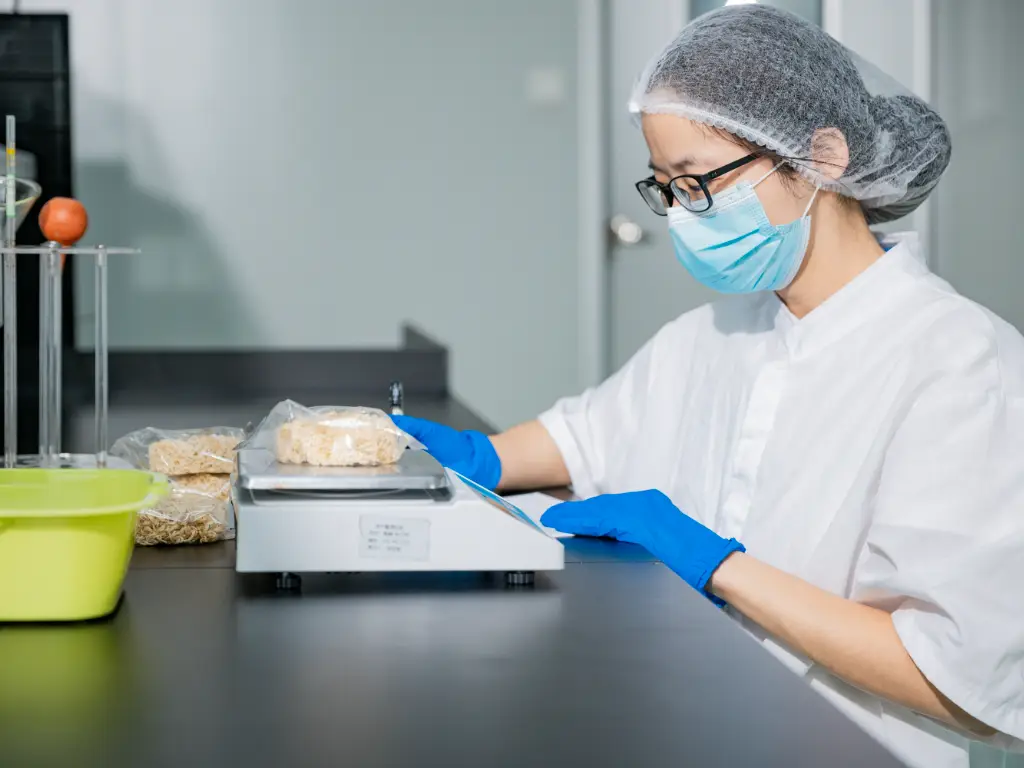 A Kimdee employee weighs the dough in the laboratory using a scale and then records in a document whether the weight of the dough meets the order requirements