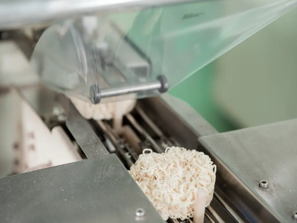 In Kimdee's outer packaging workshop, workers are packing packaged organic noodles into secondary plastic packaging