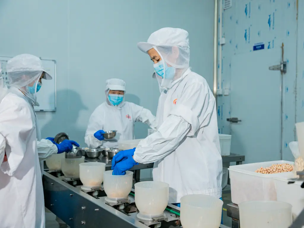 In Kimdee's prepared food workshop, workers are filling bottles at the filling line