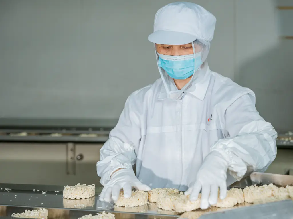 Kimdee workers are shaping noodles beside the production line