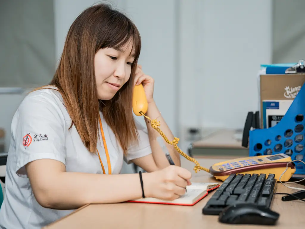 Kingdee worker answers a customer's call at the computer desk