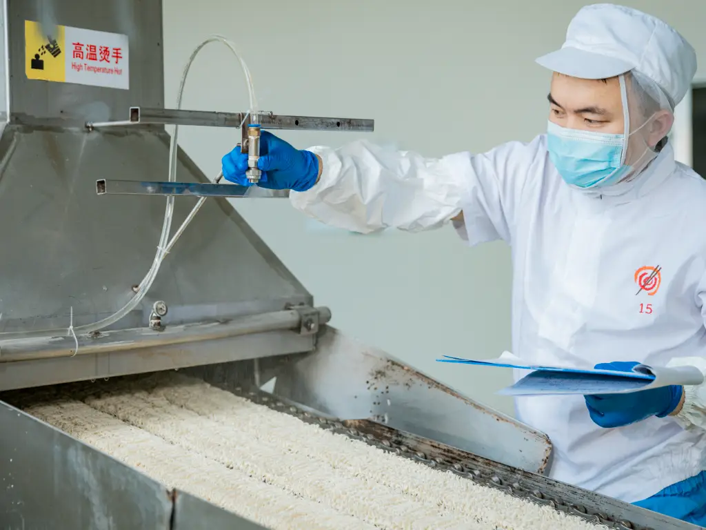 Workers checking noodles on the production line